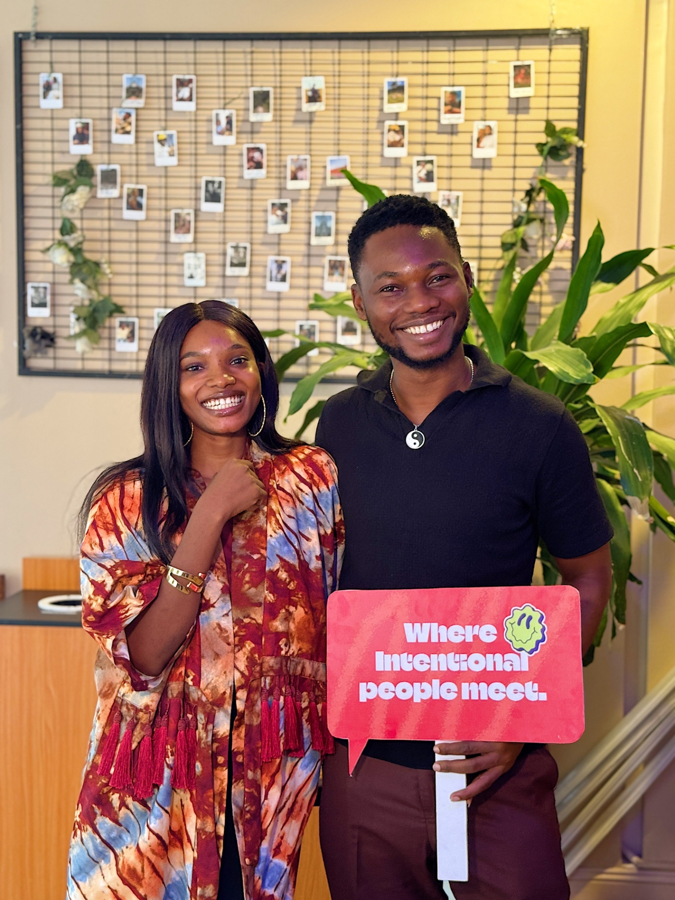Two members holding 'Where intentional people meet' sign