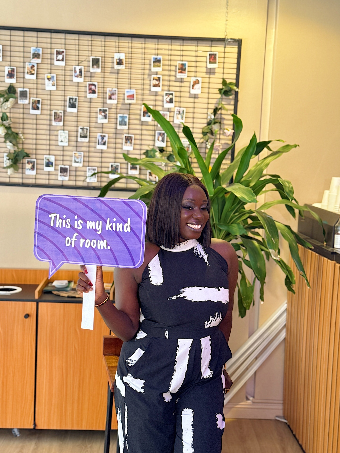 Member smiling with 'This is my kind of room' sign