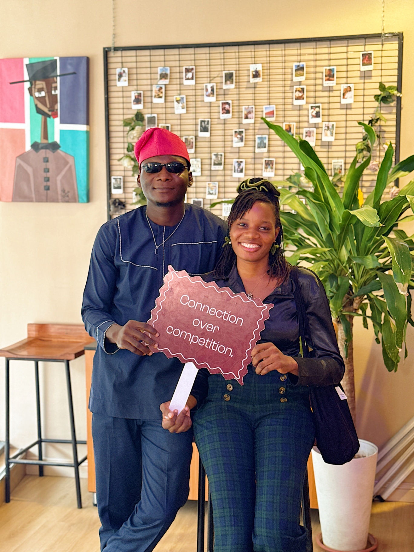 Couple posing with 'Connection over competition' sign
