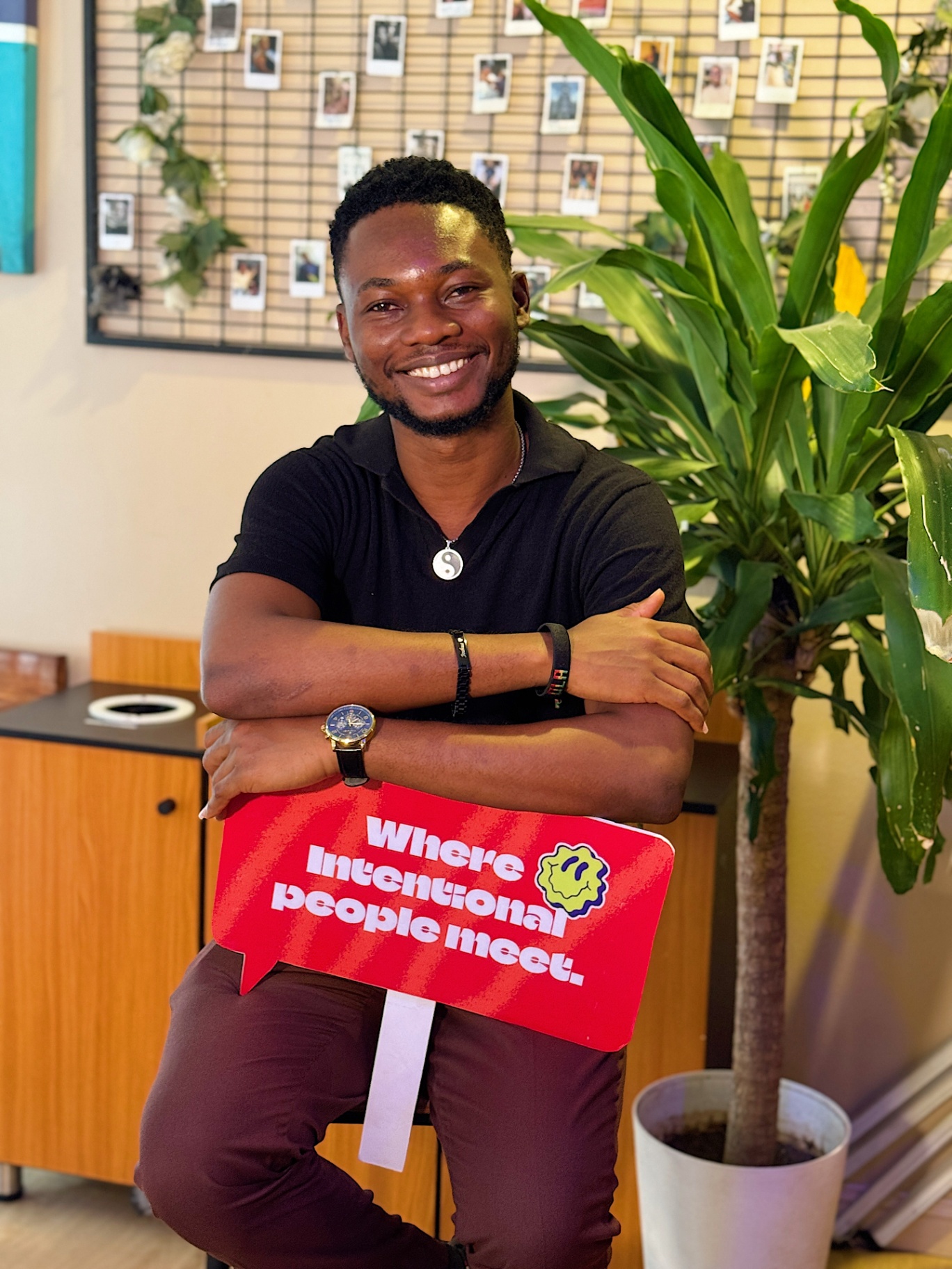 Member smiling with 'Where intentional people meet' sign